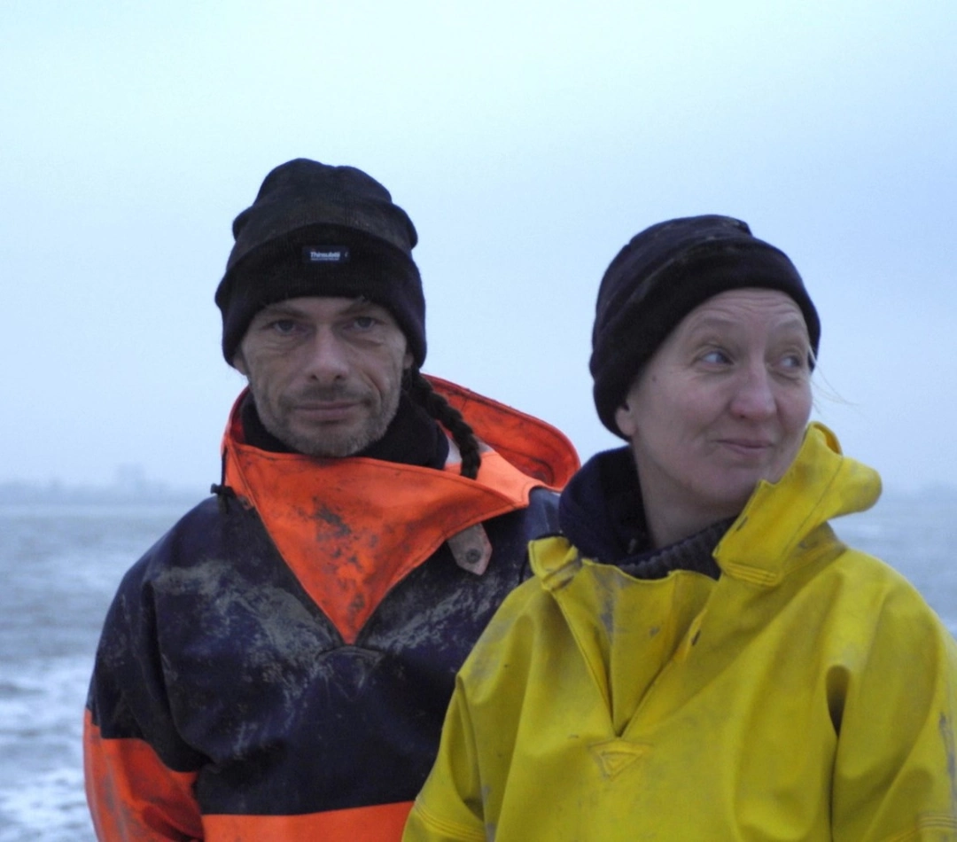 Frontales Foto von einem Mann und einer Frau, umgeben von winterlicher Meereslandschaft - gebana.com