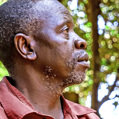 Der französische Satz „Photo d'un agriculteur kenyan de profil, entouré d'une forêt - gebana.com