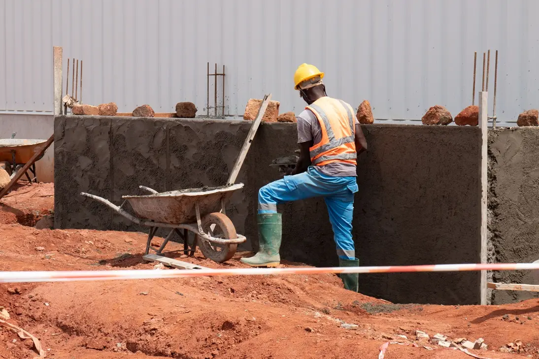 Photo d'un ouvrier construisant un mur - gebana.com