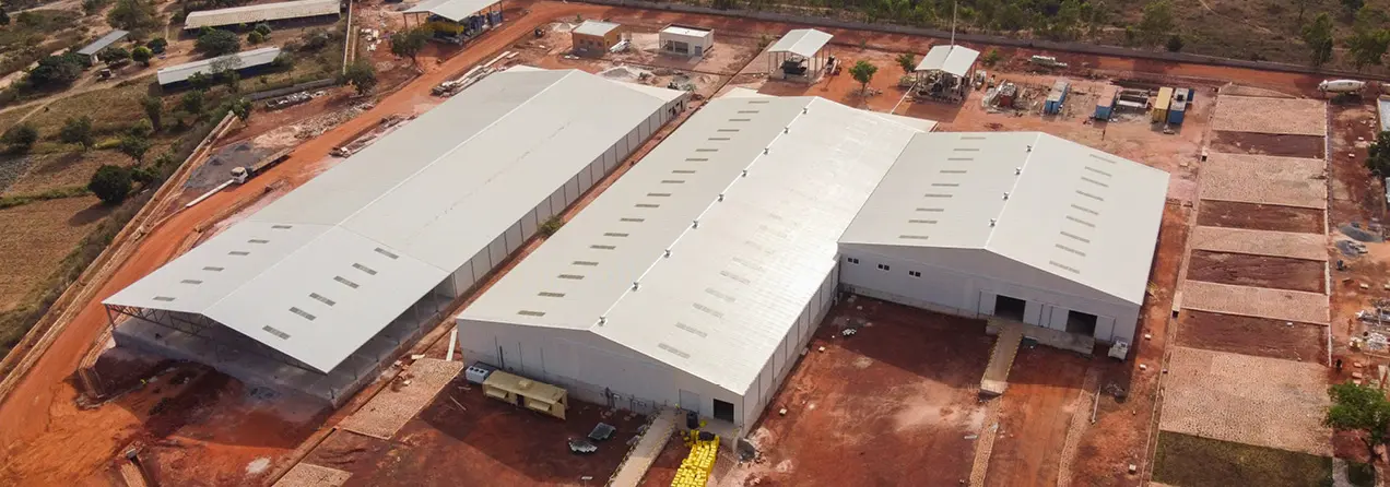 Image of three big and white factory buildings