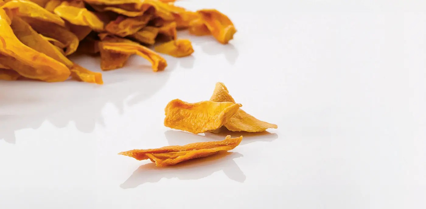 A pile of dried mangos on a white background