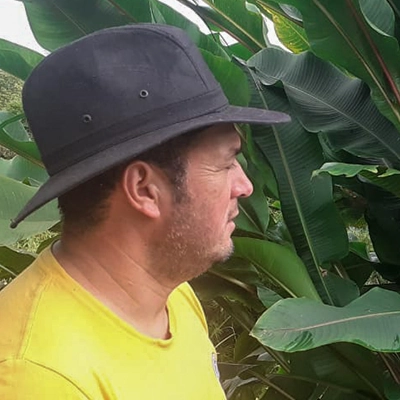 Photo d'un agriculteur colombien de profil, entouré de plantes vertes - gebana.com