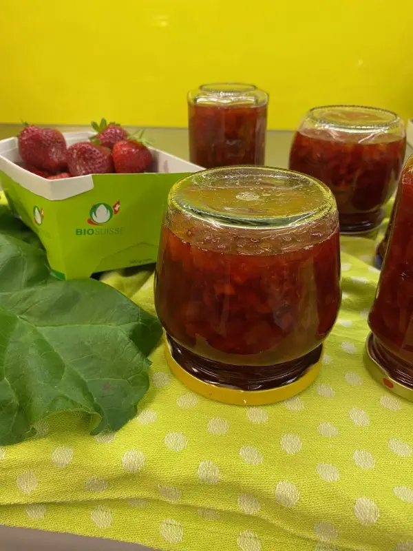 Photo of several jars of strawberry jam and a box of fresh strawberries, gebana.com