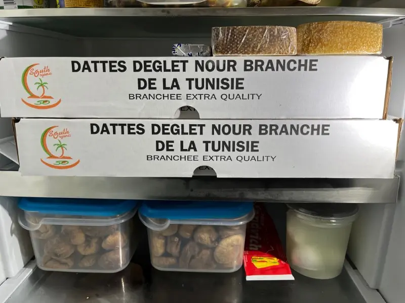 Photo of the inside of a fridge with two large boxes of dates from Tunisia, gebana.com