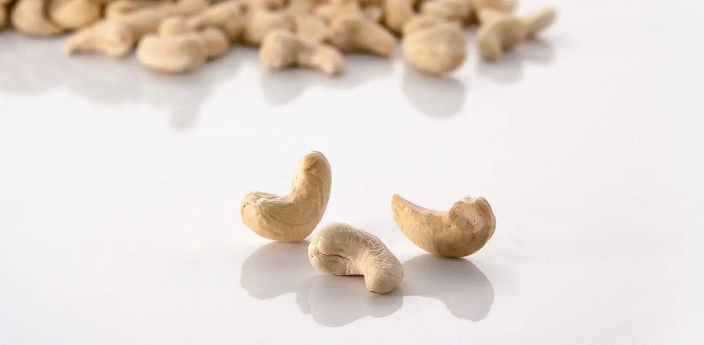 A pile of cashews on a white background