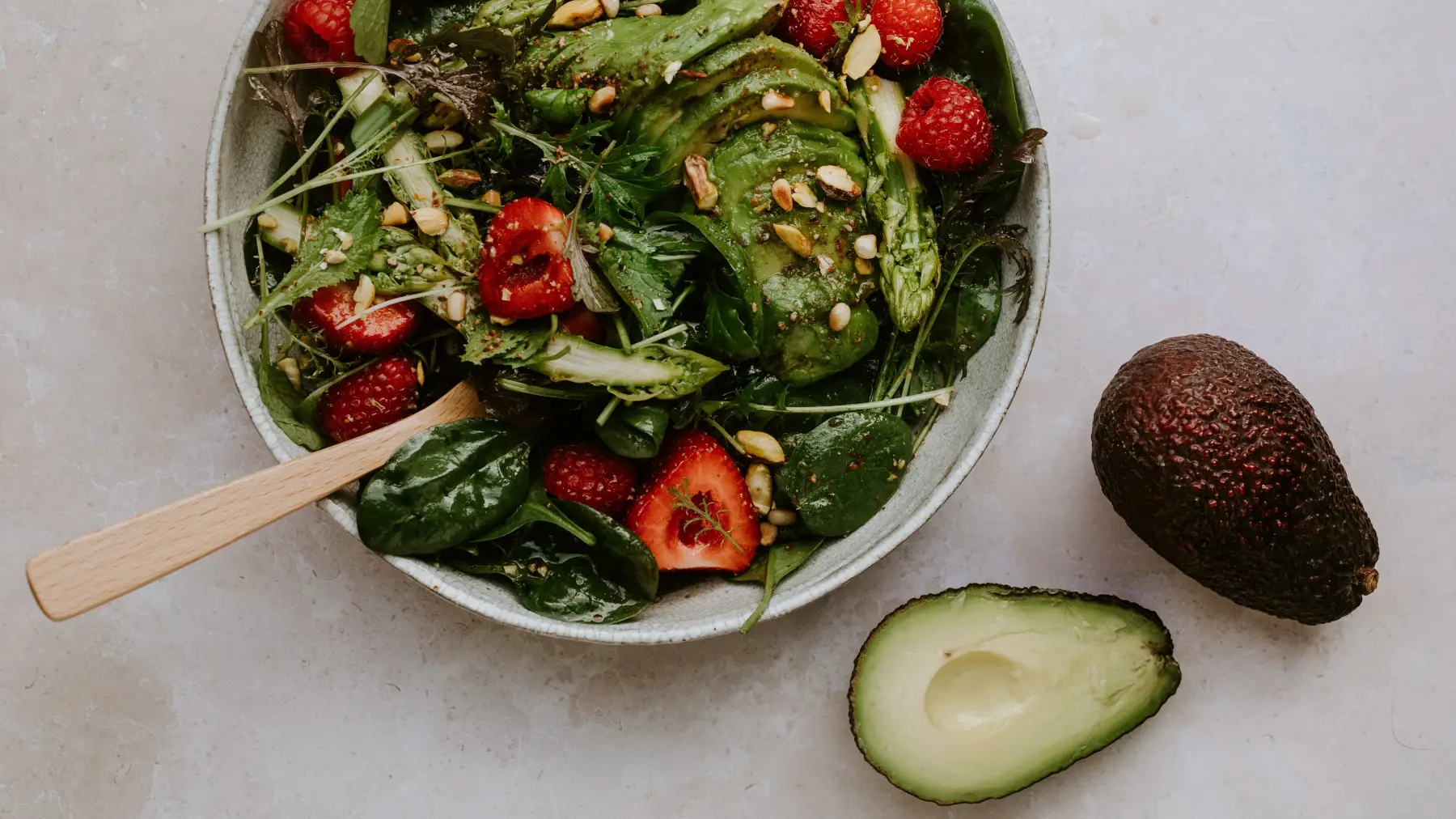 Babyspinatsalat mit Avocado, grünem Spargel und roten Früchten