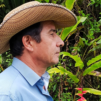 Photo d'un agriculteur colombien de profil, entouré de plantes vertes - gebana.com