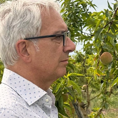 Photo d'un agriculteur italien de profil, devant un pêcher - gebana.com